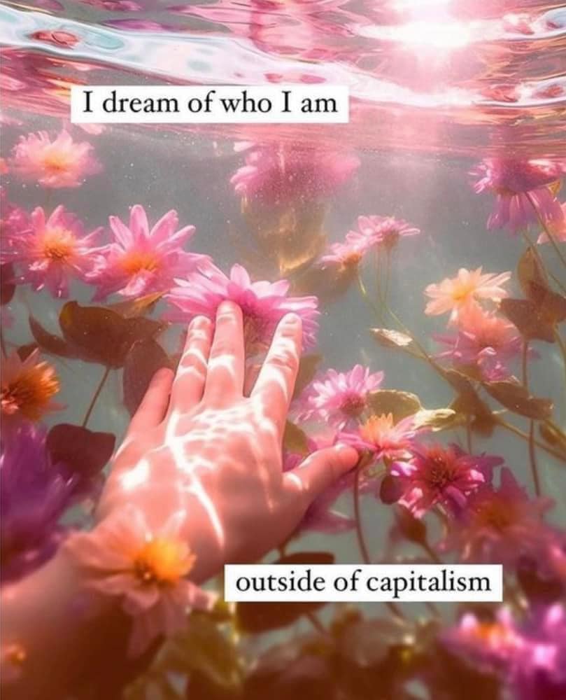 This meme is a humorous commentary on the idea that people's self-perceptions are often at odds with their actual reality. The image shows a hand reaching up from the depths of a pool of water, surrounded by flowers, with the phrase "I dream of who I am" written above it. The text below it says "outside of capitalism," suggesting that the person's aspirations are not being fulfilled by the societal norms of capitalism.