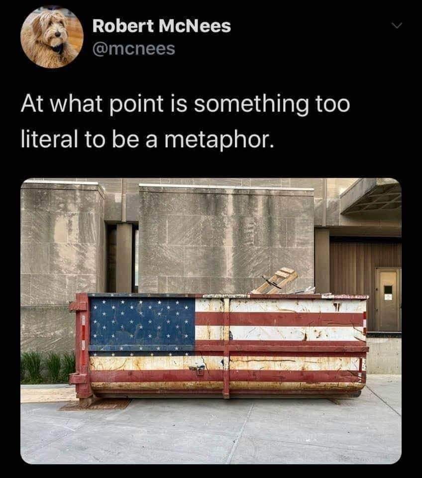 The meme is a photo of a dumpster with a large American flag painted on its side, but the flag is badly torn and ripped, with several large holes and tears. The text above the image reads, "At what point is something too literal to be a metaphor?"
