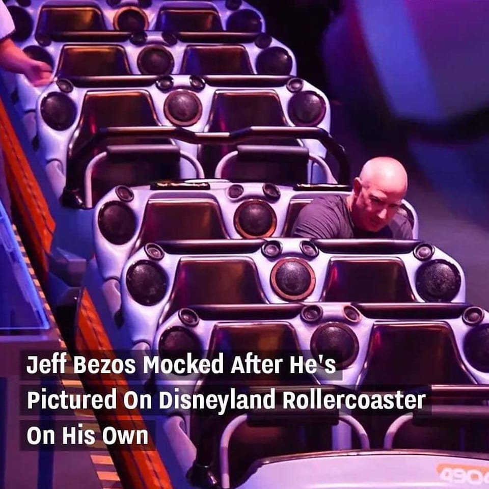 The meme is a photo of a roller coaster with a man screaming in the front seat, accompanied by the text "Jeff Bezos Mocked After He's Pictured On Disneyland Rollercoaster On His Own". The image is a humorous take on a news article, implying that the wealthy and powerful are not immune to public ridicule.