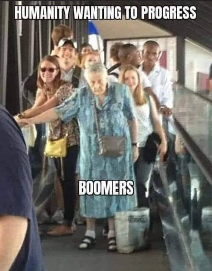 This meme is a humorous image of an elderly woman struggling to keep up with a crowd of people on a staircase, with many younger individuals passing by her. The text "HUMANS WANTING TO PROGRESS" is overlaid at the top, and "BOOMERS" is written below the image, implying that the elderly woman is a stereotypical "boomer" who is struggling to keep up with the pace of modern society. The meme is meant to be ironic and humorous, poking fun at the stereotype that older generations are often out of touch with modern technology and societal norms.