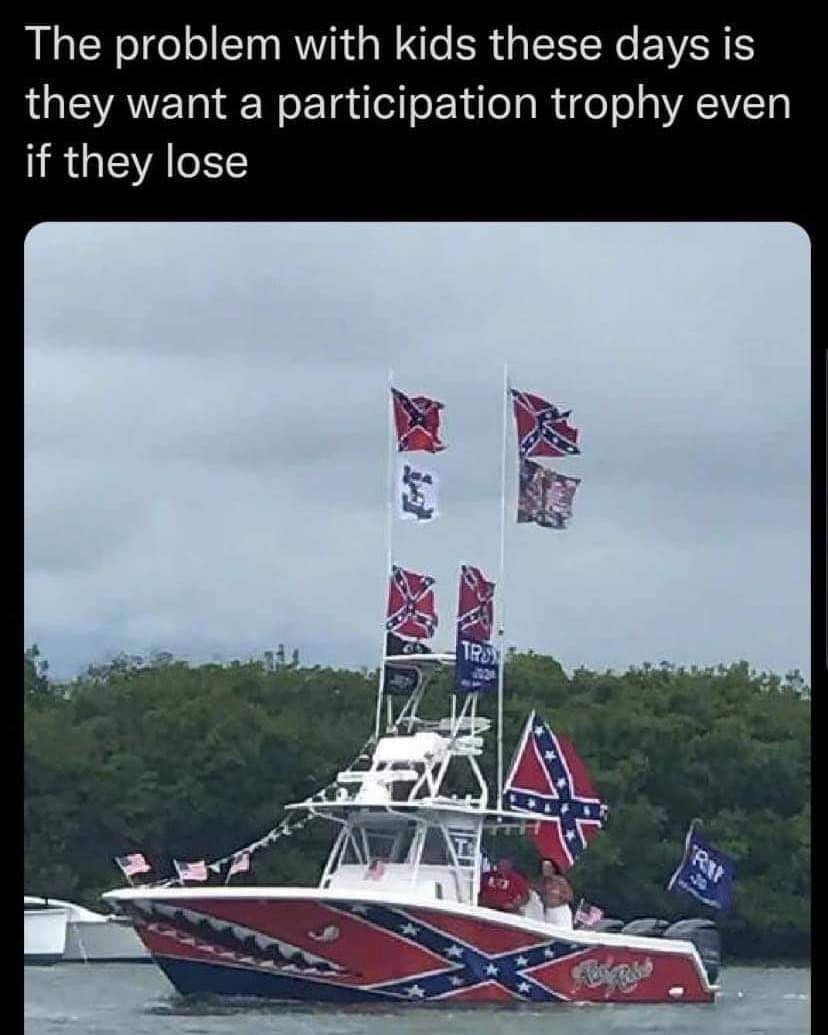 This meme is a humorous image of a boat with a Confederate flag and a Trump 2024 flag, implying that the owner is trying to make a statement about their politics. The text above the image reads: "The problem with kids these days is they want a participation trophy even if they lose." The meme is poking fun at the idea that people are trying to make a statement about their politics by using a boat with a Confederate flag, which is a symbol of the American Civil War and a symbol of racism and slavery.