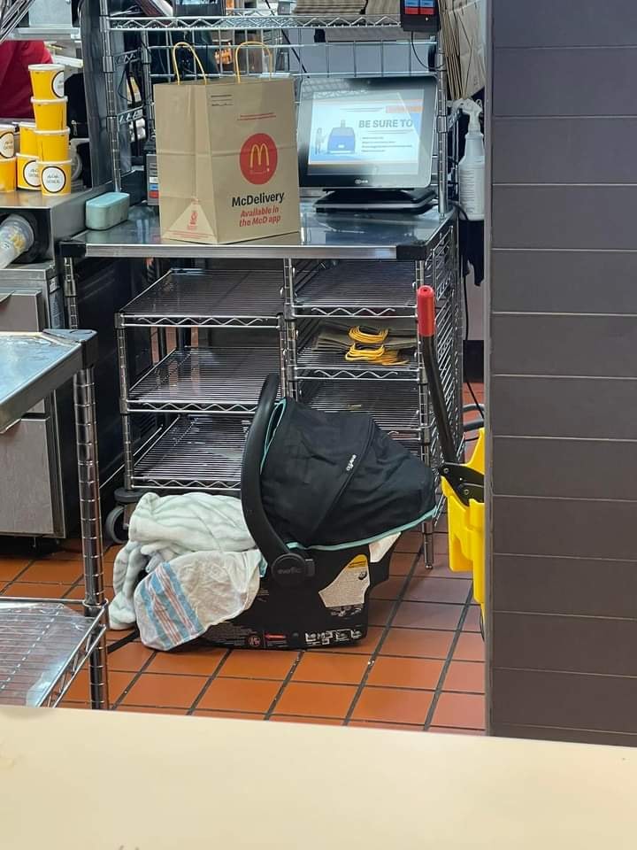 This meme is a photo of a baby in a car seat sitting in a McDonald's playplace, surrounded by toys and a McDonald's menu board. The caption "When you're a 3-year-old and you're trying to get a Happy Meal" is likely being referenced, but it's not actually on the image. The image is humorous because it's a surreal and unexpected scene, and the juxtaposition of a baby in a car seat in a McDonald's playplace is absurd and playful.