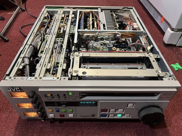 Okay, let's break down this image of the disassembled JVC VCR through several theoretical lenses. Please note that applying these lenses to an *object* like this involves interpretation and is not a literal "reading"...