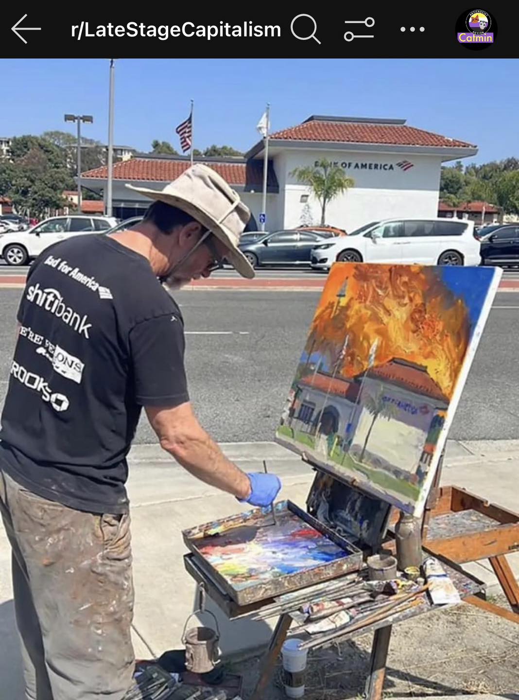 The meme is a screenshot of a Reddit post with the title "I asked my 85-year-old father to paint a picture of my new job". The image shows an elderly man standing in front of a large, unfinished painting of a building. The text "I asked my 85-year-old father to paint a picture of my new job" is written above the image, and the caption below it reads "I work at GameStop".