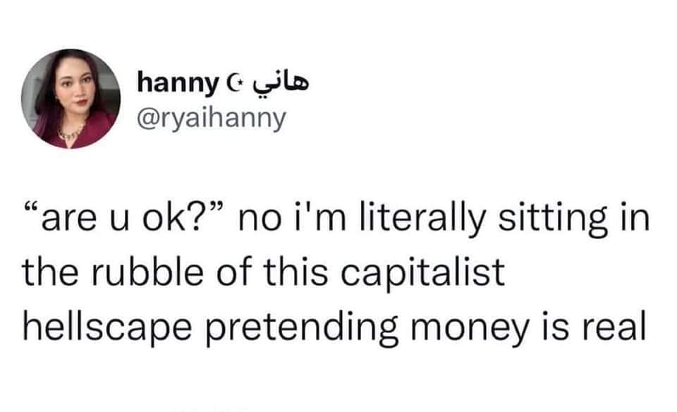 This meme is a humorous take on a common phrase, "are you okay?" The text on the image reads: "are u ok? no i'm literally sitting in the rubble of my own capitalist hellscape pretending money is real." The meme pokes fun at the idea that people often pretend to be fine when they're actually struggling, and the phrase "pretending money is real" is a clever way to express that feeling.