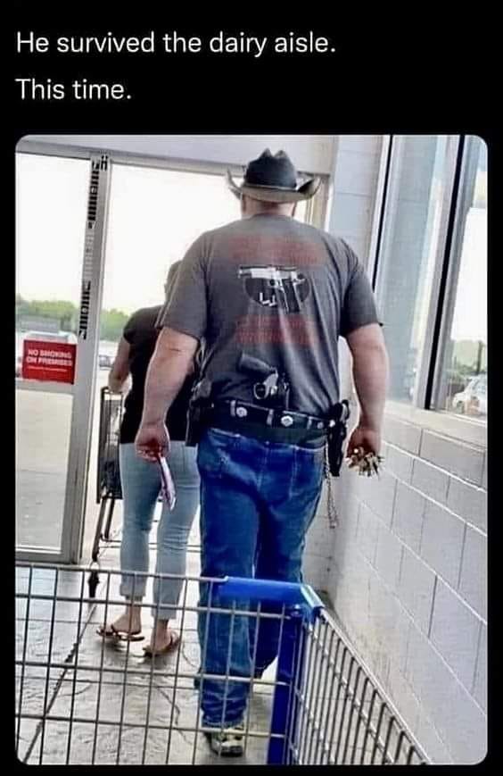 This meme features a photo of a man in a grocery store, dressed in a cowboy hat and a holstered gun on his belt. He's wearing a t-shirt with a cartoon cow and the phrase "I survived the dairy aisle". The caption above the image reads "He survived the dairy aisle. This time."