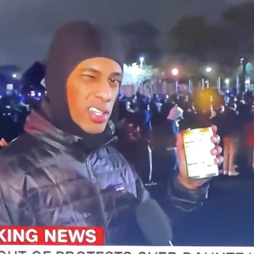 The meme is a screenshot of a news anchor, usually Keith Olbermann, with a shocked expression. In the background, a group of people are protesting and chanting "Keith Olbermann" in unison. The text at the bottom of the image reads "Keith Olbermann: We Interrupt Your Regularly Scheduled Program... to Bring You the News... of Your Own Demise".