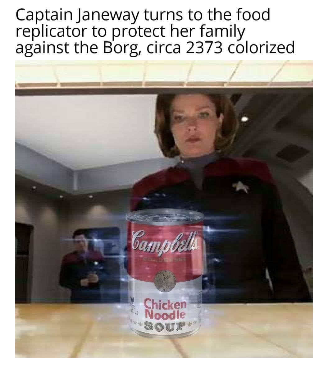 The meme features a still from the Star Trek: The Next Generation episode "The 10,000 Bedtimes" where Captain Janeway, played by Kate Mulgrew, is seen standing behind a table with a can of Campbell's chicken noodle soup.  The text above the image reads: "Captain Janeway turns to the food replicator to protect her family against the Borg, circa 2373 colorized." The image is a play on words, using a famous art piece "Campbell's Soup Cans" by Andy Warhol, which was a series of soup cans produced in 1962. The image is meant to be humorous and satirical, poking fun at the idea of Captain Janeway using a food replicator to protect her family from the Borg. The use of the word "colorized" is also a play on words, as it is not actually a colorized version of the image, but rather a reference to the fact that the original "Campbell's Soup Cans" were produced in 1962, and the image is set in 2373. The image is meant to be humorous and satirical, poking fun at the idea of Captain Janeway using a food replicator to protect her family from the Borg.