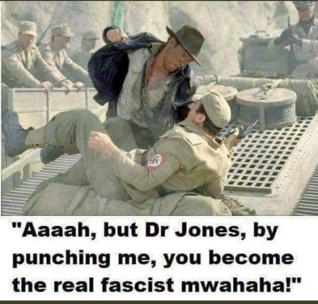 The meme features a still from the 1981 film "Raiders of the Lost Ark," where Indiana Jones is seen punching a Nazi soldier. The image is accompanied by a quote from the scene, which has been modified to read: "Aaaah, but Dr. Jones, by punching me, you become the real fascist m-wah-ha." The quote is a play on the original line, "Aaaah, but Dr. Jones, by punching me, you become the real Nazi m-wah-ha." The image is meant to be humorous and satirical, poking fun at the idea of someone becoming a "fascist" or "Nazi" simply by punching someone. The use of the word "m-wah-ha" is also a reference to the sound effect from the film, which is used to emphasis the impact of the punch. Overall, the meme is a ligh-hearted and irreverent take on the classic film.