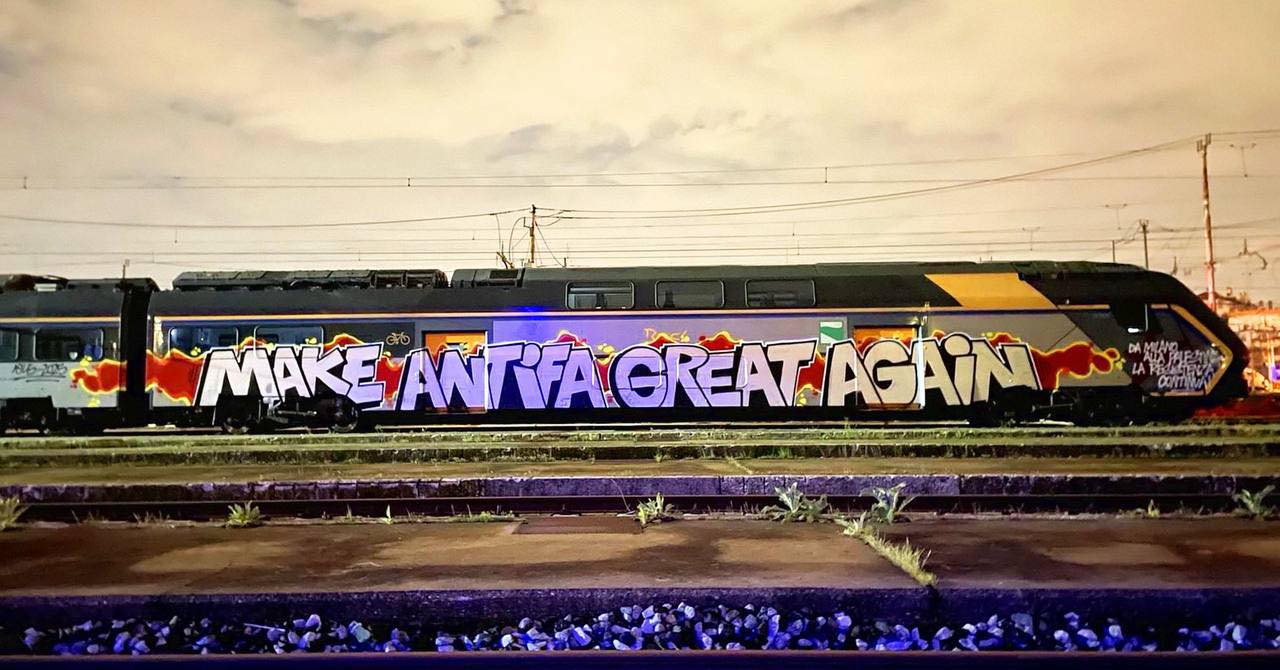 This meme is an image of a graffiti-covered train car with the phrase "Make America Great Again" (MAGA) spray-painted on it, but with a twist: the "M" and "A" have been replaced with "Make" and "Anti" respectively, and the "G" has been replaced with "F" (a common typo). The result is "Make Anti Fa Great Again", a play on the original MAGA slogan that is now a reference to the far-right group Antifa.