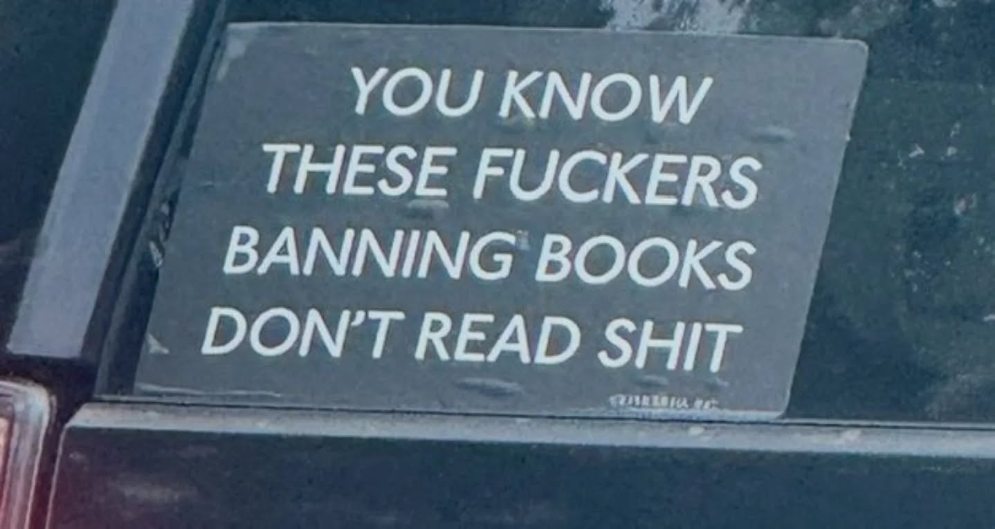 This meme is a humorous image of a bumper sticker that has been placed on a car. The text on the sticker reads: "You know these f**kers are banning books, don't read sh*t." The image is a tongue-in-cheek commentary on the controversy surrounding book banning, suggesting that the best way to respond to it is to ignore it and continue reading.