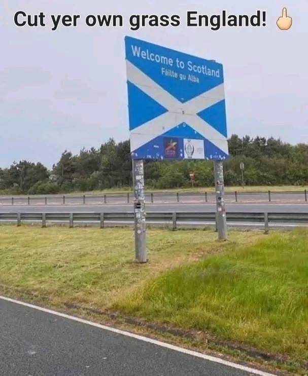 The meme is a humorous reference to the traditional Scottish phrase "cut your own grass" being modified to "cut your own grass England". The image shows a sign at the Scottish-English border that says "Welcome to Scotland" with a Scottish flag, but someone has added a new sign below it that says "Cut yer own grass England" in a similar style to the original sign. The text at the top of the image reads "Cut yer own grass England".