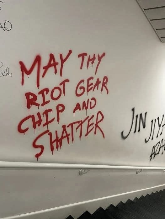 The meme is a photo of a whiteboard with a quote from Shakespeare's "Romeo and Juliet" rewritten as a threat. The quote, "Romeo, Romeo, where...?" is replaced with "Riot, riot, riot...". The phrase "Romeo, Romeo, where...?" is replaced with "Riot, riot, riot..." The quote is then rewritten as "May thy riot gear chip and shatter".