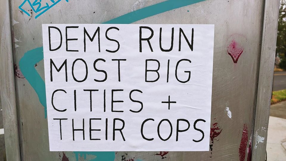 The meme features a sign with the text "DEMS RUN MOST BIG CITIES - THEIR COPS ARE WORSE THAN THE CRIMINALS THEY PROTECT" on a metal surface with graffiti. The sign is likely intended to express a negative opinion about the Democratic Party's control of many major cities in the United States and the perceived quality of law enforcement in those areas. The meme may be used to critique the party's handling of public safety or to express frustration with the state of law enforcement in urban areas.