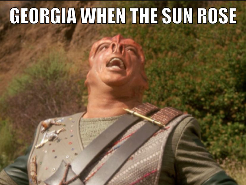 This meme is an image of a character from the TV show "Star Trek: The Next Generation" with a shocked expression. The character, who is a Klingon warrior, is shown with his mouth open in a wide, angry scream. The text above the image reads "Georgia when the sun rises". The implication is that the character's reaction is similar to how someone from Georgia (a state in the US) might feel when the sun rises, perhaps due to the intense heat and humidity that is common in the state during the summer.