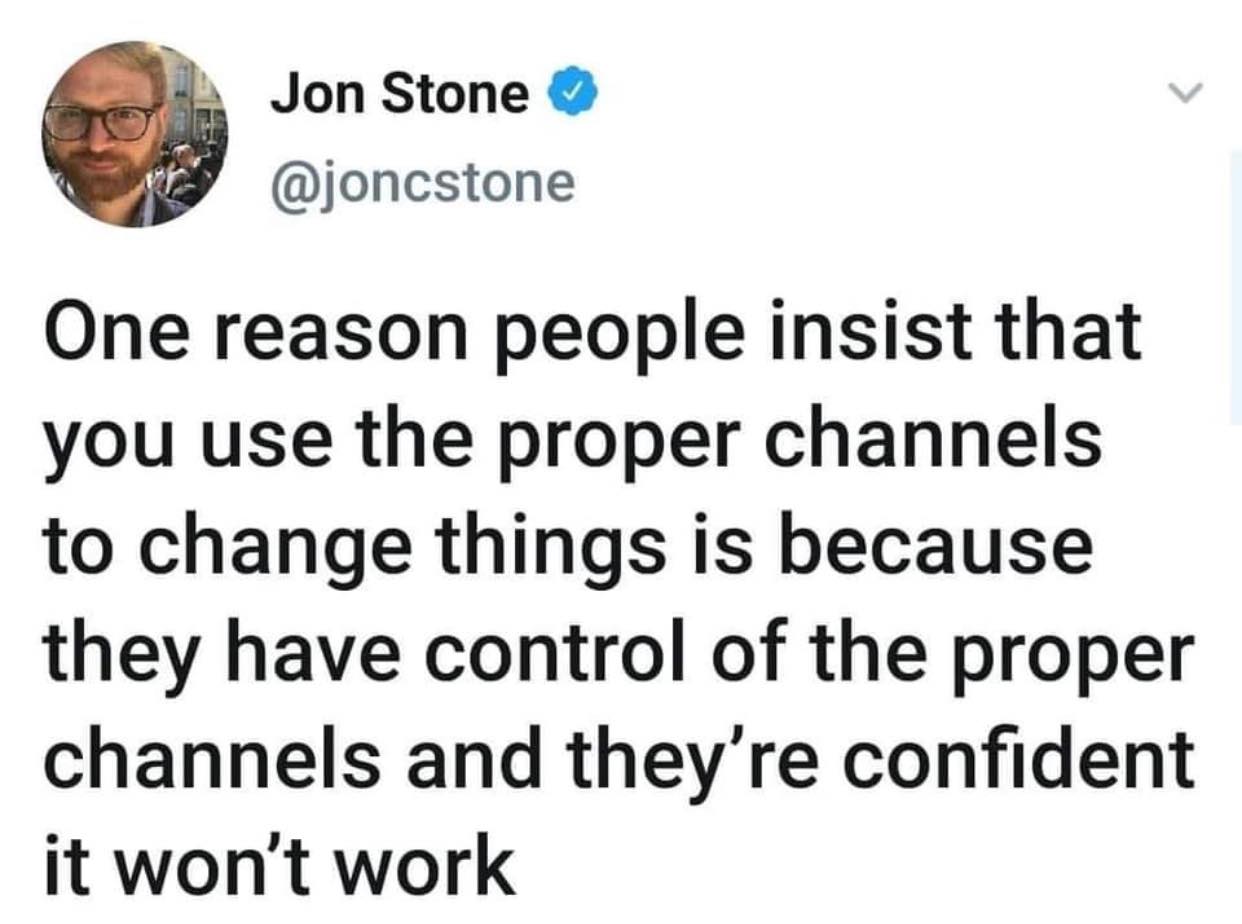 The image shows a tweet by Jon Stone. It features a circular photo of a man with blond hair and glasses, and text that reads, "One reason people insist that you use the proper channels to change things is because they have control of the proper channels and they're confident it won't work." The tweet has a blue checkmark indicating it is verified. The background is white. The tweet is humorous because it pokes fun at people who insist on using proper channels to make changes, but are actually just trying to maintain their control over those channels. The tweet suggests that these people are confident that their efforts will not be successful, which is a clever observation.