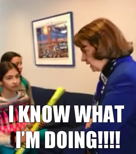 This meme features a photo of a woman in a blue blazer, standing in a classroom or office setting, with a student holding a yellow stick. The student is looking up at the woman with a look of surprise or concern. The text "I KNOW WHAT I'M DOING!!!" is written in a bold, all-caps font across the top of the image, suggesting that the woman is trying to reassure the student that she is in control of the situation.