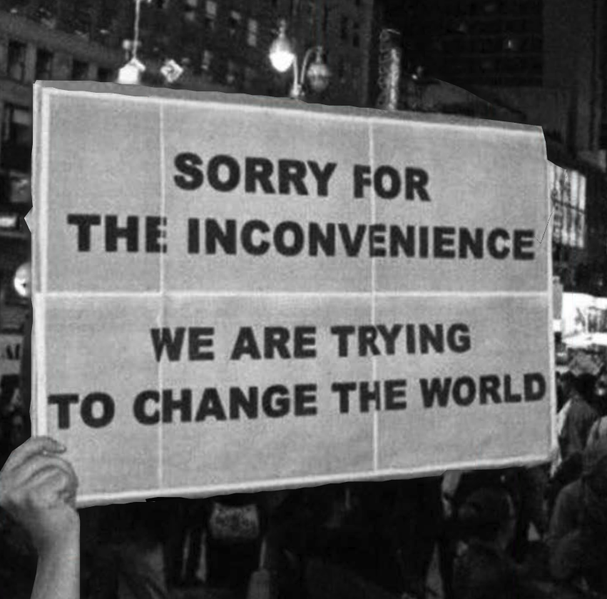 This meme is a humorous take on the concept of an "inconvenience" being a catalyst for change. The image is likely a photo of a protest or demonstration, with a sign or placard held up by a person in the crowd. The text on the sign reads, "Sorry for the inconvenience, we are trying to change the world."
