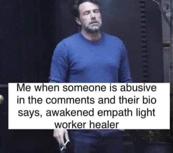 This meme features a photo of actor Ben Affleck looking unimpressed. The text overlay reads: "Me when someone is abusive in the comments and their bio says, 'awakened empath light worker healer'." The image pokes fun at the irony of someone being abusive online while claiming to be a spiritual or empathetic person.