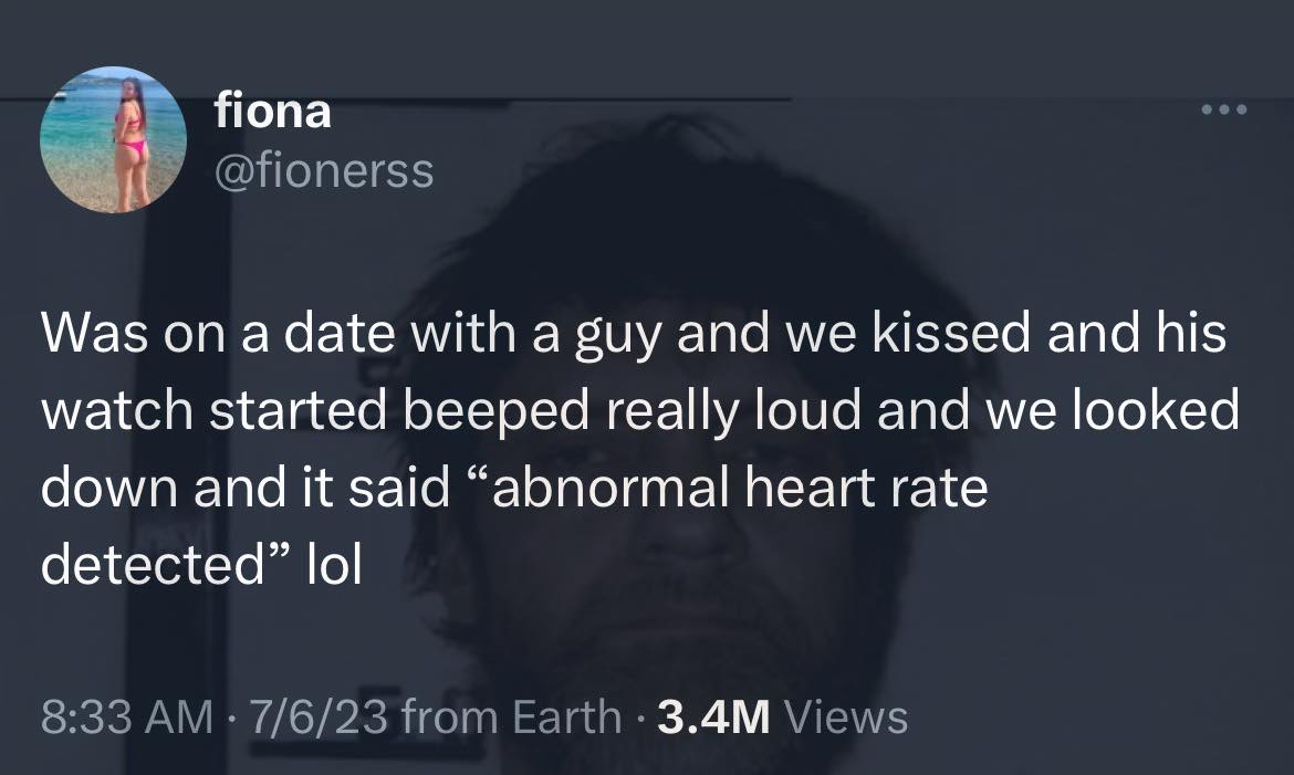 This meme is a screenshot of a tweet from a user named "fiona" (or possibly a different user with the same username). The tweet reads: "Was on a date with a guy and we kissed and his watch started beeping loudly and he said 'abnormal heart rate detected' lol".