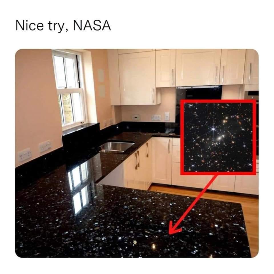 This meme is a humorous image of a kitchen with a black countertop that has a faint, starry pattern resembling the night sky. The text "Nice try, NASA" is overlaid on the image, implying that the countertop's design is so good it could have been created by NASA, the US space agency. The meme is likely poking fun at the idea that even the most mundane objects can be made to look like something out of space.