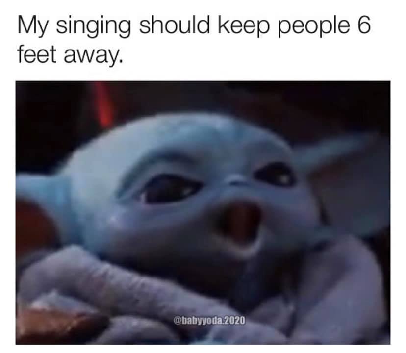 This meme features a still image of a character from the Star Wars franchise, specifically Baby Yoda from "The Mandalorian." The image shows Baby Yoda with a shocked expression, as if he's just heard something surprising. The text above the image reads, "I'm making it through this pandemic, but my singing voice is not."