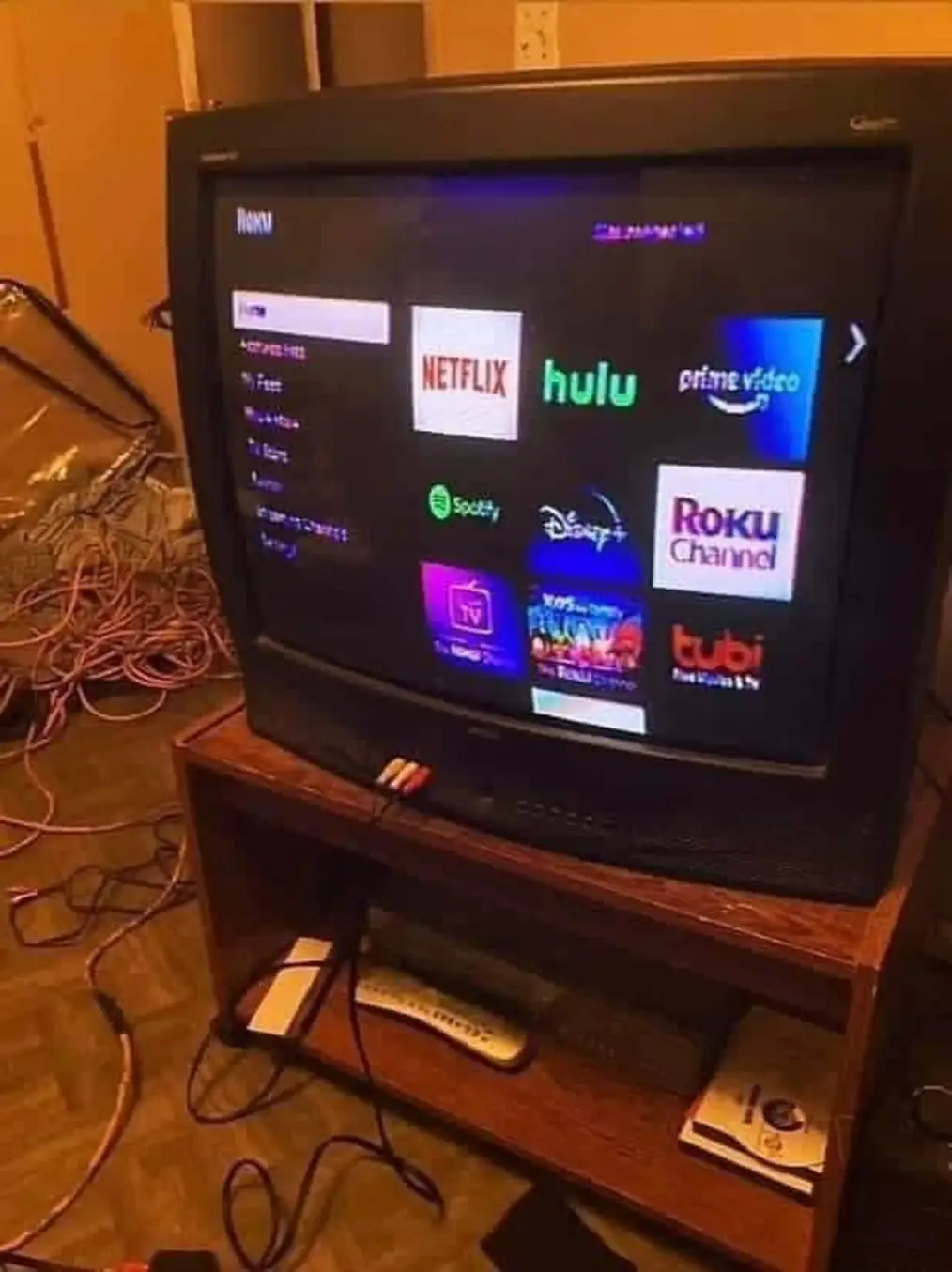 The meme is an image of a TV with a frozen screen displaying a list of streaming apps, including Netflix, Hulu, and Amazon Prime. The text "Help me" is written on the screen, implying that the user is having trouble accessing their favorite shows. The image is likely humorous because it pokes fun at the frustration of dealing with a frozen TV screen.