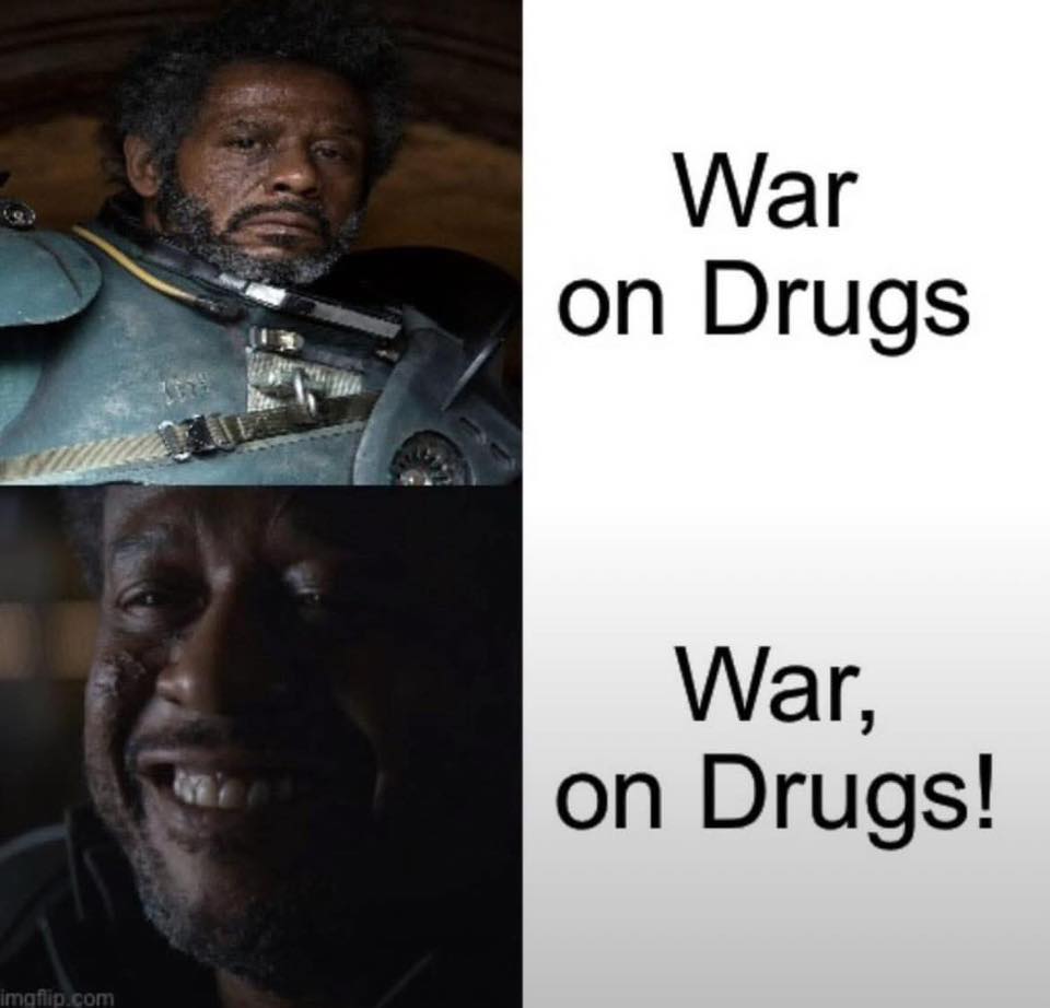 This meme is a humorous comparison between two characters, one from a movie and one from a TV show, both known for their tough and intimidating personas. The image juxtaposes a character from the movie "Mad Max: Fury Road" with a character from the TV show "Star Wars: The Mandalorian". The text "War on Drugs" appears on the left, while the text "War on Drugs" is replaced with "War, on Drugs!" on the right.