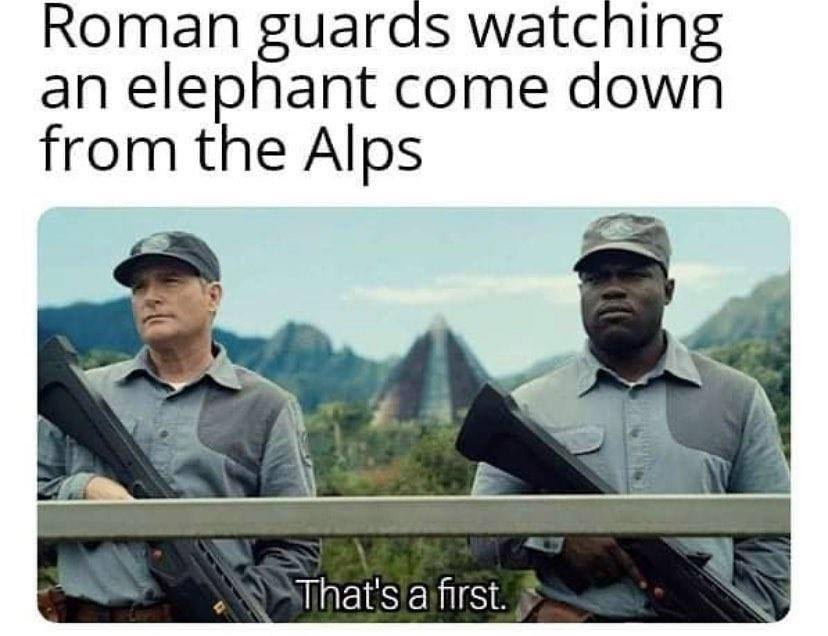 The meme is a humorous image that juxtaposes a historical event with a modern-day scenario. The text at the top reads "Roman guards watching an elephant come down from the Alps" and the image shows two men holding guns, looking serious, with a caption "That's a first." The meme is poking fun at the idea of Roman guards being surprised by an elephant, a creature that would have been rare in their time, and the "that's a first" phrase is a sarcastic comment on the absurdity of the situation.