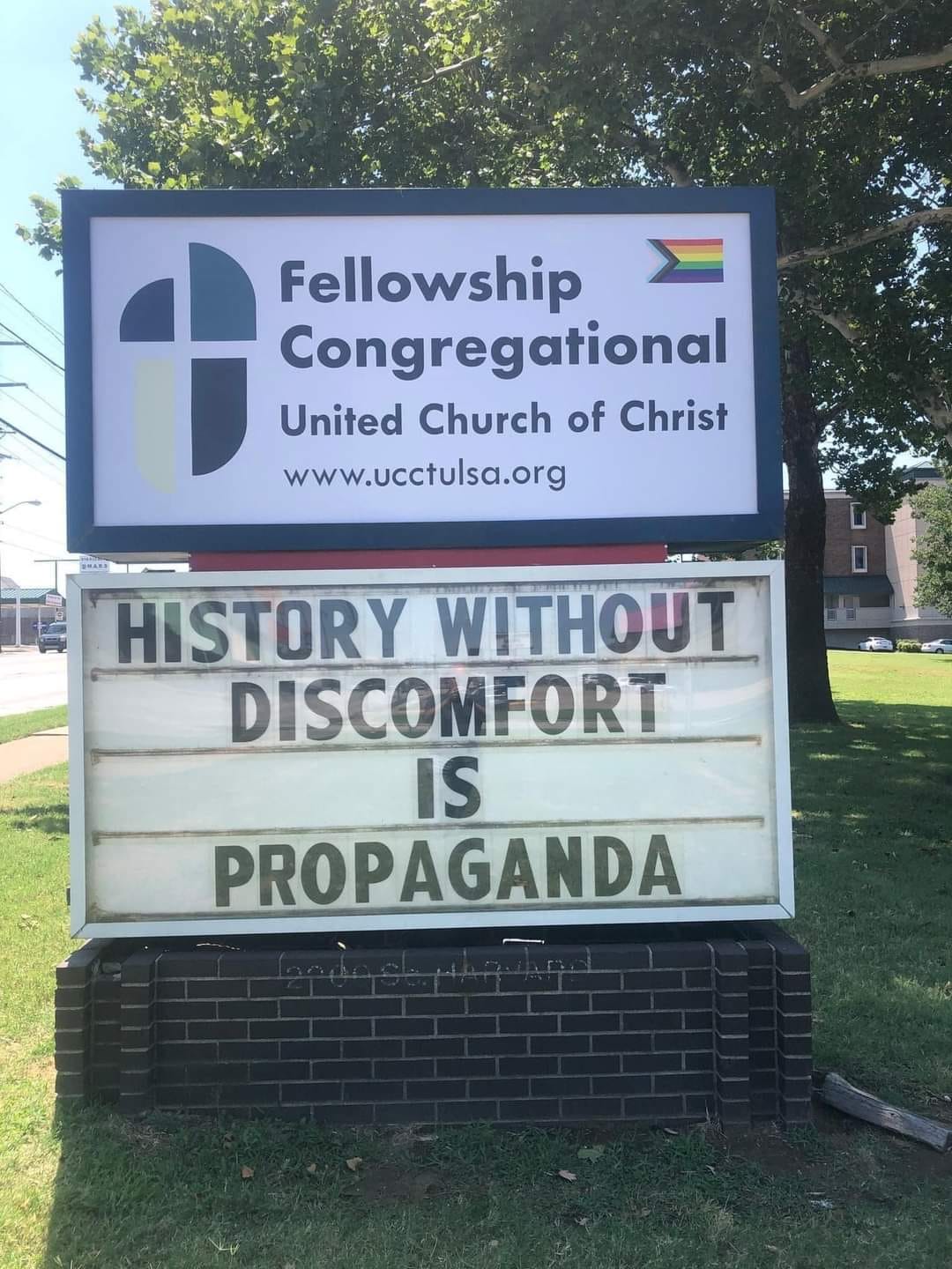 This meme is a humorous take on the concept of "history without discomfort" being a form of propaganda. The image features a sign with a quote that reads: "History without discomfort is propaganda." The sign is likely from a church or community center, and the quote suggests that the organization is trying to avoid uncomfortable or difficult conversations about historical events.