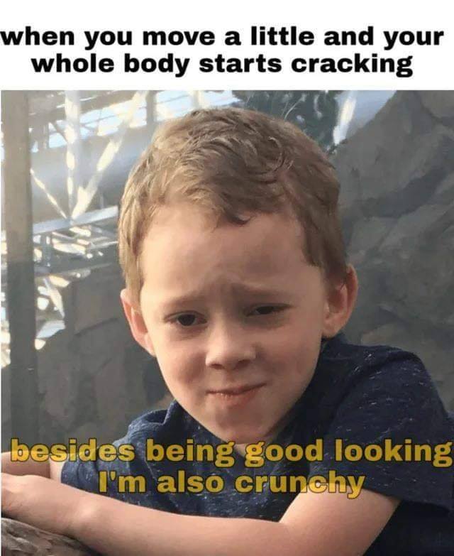 This meme features a photo of a young boy with a mischievous expression. The text overlay reads: "When you move a little and your whole body starts cracking" and "Besides being good looking I'm also crunchy". The meme is likely used to poke fun at the idea of being both physically attractive and having a quirky, offbeat personality.