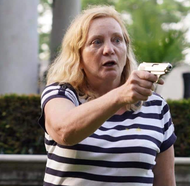The meme is an image of a woman with a shocked expression, holding a gun and looking directly at the viewer. The text "I can SMELL THE TEA" appears in a bold, cartoonish font above her head, implying that she's about to take action or make a bold move. The overall tone is humorous and exaggerated, implying that the woman is ready to take on whatever challenge or situation comes her way.