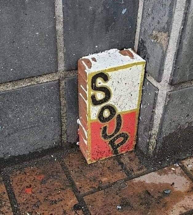 The meme is an image of a brick with the word "SOUP" painted on it, but with the "S" and "P" letters turned around to face each other, as if they're being held in a kiss. The image is a playful reference to the classic "kiss" meme, where two characters are shown embracing with their lips. The text "SOUP" is a clever play on words, using the letters to form a romantic gesture.