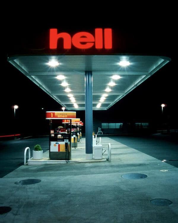This meme features a photo of a Shell gas station at night, with the word "hell" written in bold, red letters above the pumps. The image is meant to be humorous and ironic, implying that the gas station is literally located in hell. The text is likely a play on the company's name, "Shell", and the word "hell" to create a humorous and unexpected connection.