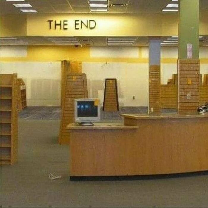This meme is a humorous image of a nearly empty bookstore or library, with a single shelf or desk remaining. The text "THE END" is displayed prominently on a wall or sign above the remaining shelf, implying that the store has finally reached its last book or customer. The image is likely intended to be ironic or humorous, suggesting that the store has been completely depleted of its inventory and is now ready to be closed.