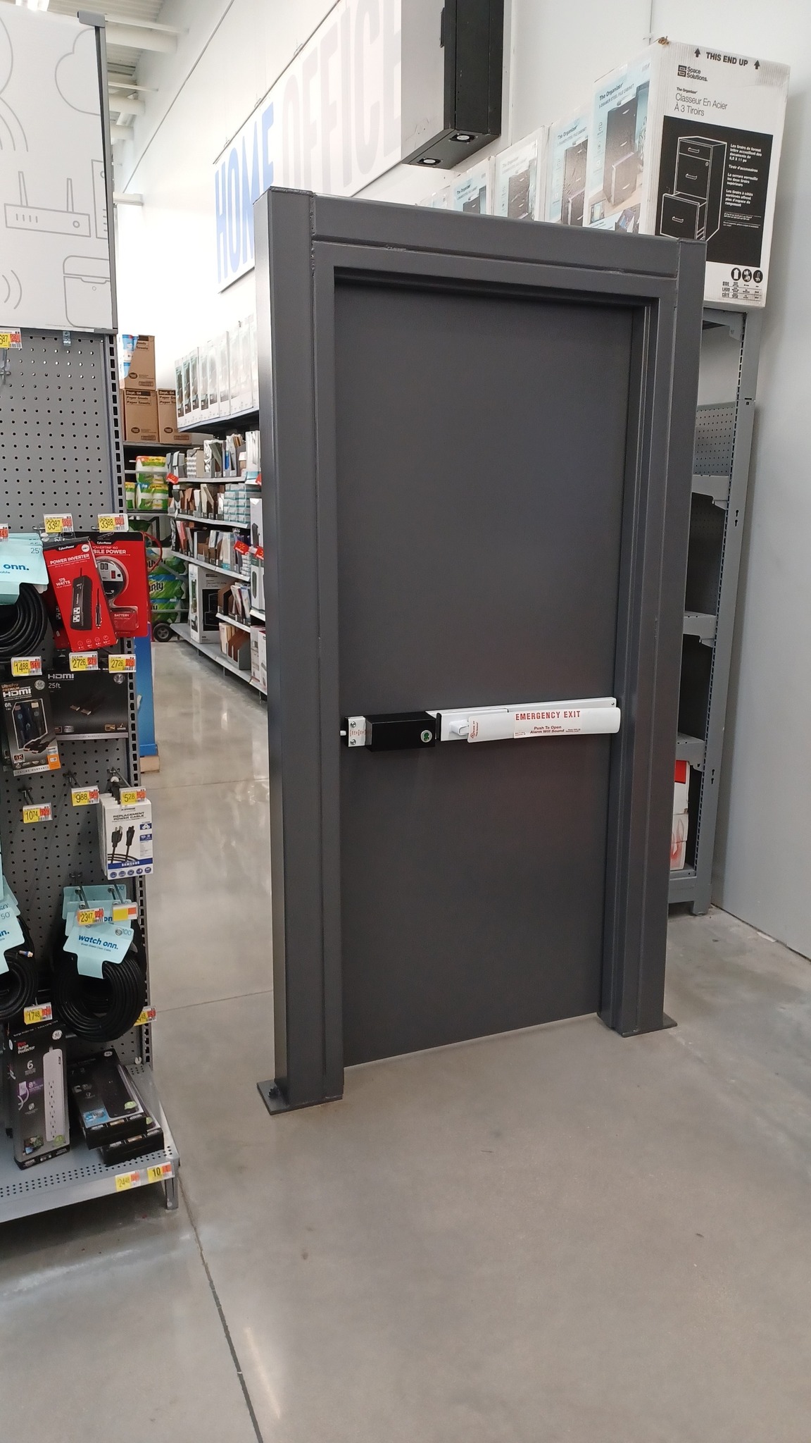 The meme is a photo of a large, metal door in a store with a sign on it that says "EMERGENCY EXIT". The door is in a store's aisle, surrounded by shelves of products, and has a sign that says "EMERGENCY EXIT" in bold letters. The door is meant to be humorous, implying that someone is so desperate to escape the store that they're using the emergency exit in the middle of the aisle.