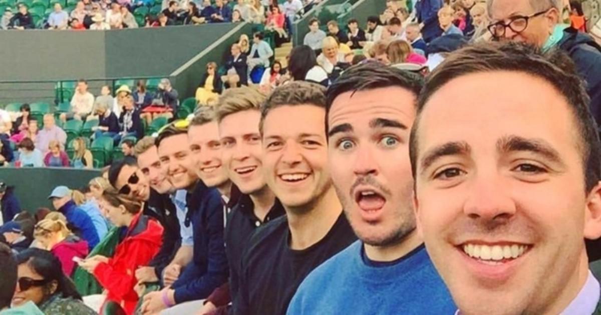 This meme features a group of friends at a concert or festival, all of whom are smiling and looking directly at the camera. The text "In 2-3 sentences, describe this meme for someone who cannot see it" is overlaid on the image, creating a humorous irony. The meme is likely meant to poke fun at the absurdity of having to describe a visual image in a text-based format.