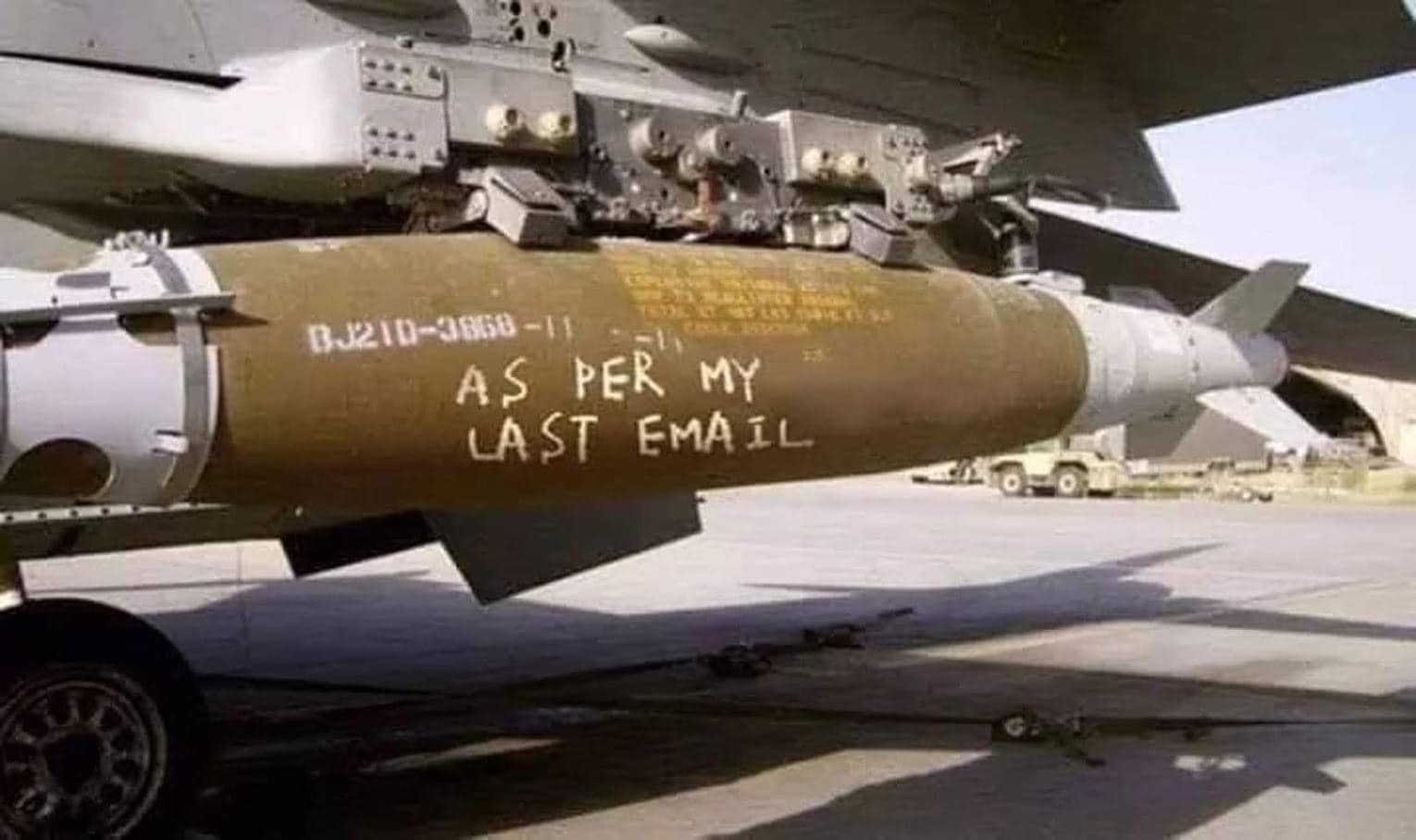 The meme is an image of a bomb with a humorous message. The text on the bomb reads: "As per my last email". The joke is that the bomb is literally following the instructions from a previous email, implying that the email was a request to detonate the bomb.