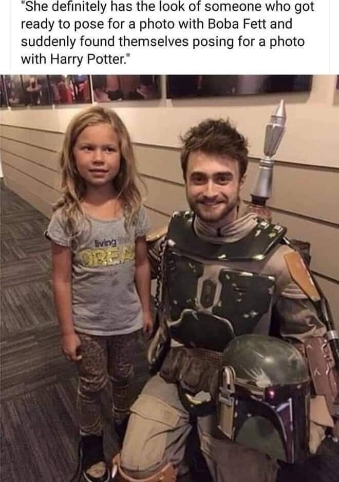 This meme is a humorous image of Daniel Radcliffe, the actor who played Harry Potter, posing with a young fan who is dressed as a character from the Harry Potter series. The text at the top of the image reads: "She definitely has the look of someone who got ready to pose for a photo with Boba Fett and suddenly realized she's standing next to Harry Potter." The image is a playful take on the idea that a young fan's expectations of meeting a famous character are not what they actually get.