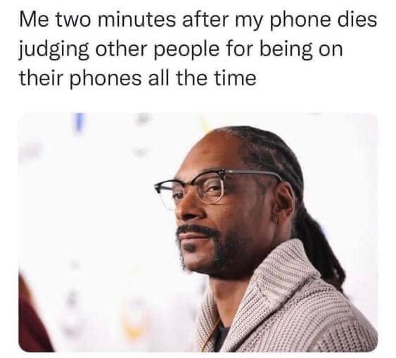 The meme is a humorous image of Snoop Dogg with a caption that reads: "Me two minutes after my phone dies judging other people for being on their phones all the time." The image is a playful take on the common experience of feeling judgmental towards others when you're not able to use your phone, only to feel hypocritical when your phone dies and you're forced to put down your own device.