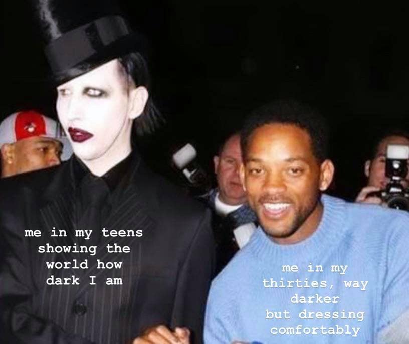 This meme features a photo of Marilyn Manson (a musician known for his dark aesthetic) standing next to a young, smiling Will Smith. The text on the image reads: "Me in my teens, showing the world how dark I am / Me in my 30s, way darker, but dressing comfortably." The meme humorously contrasts the persona of a teenager who wants to appear dark and edgy with that of a 30-year-old who is still trying to maintain a similar image but is now more comfortable with it.