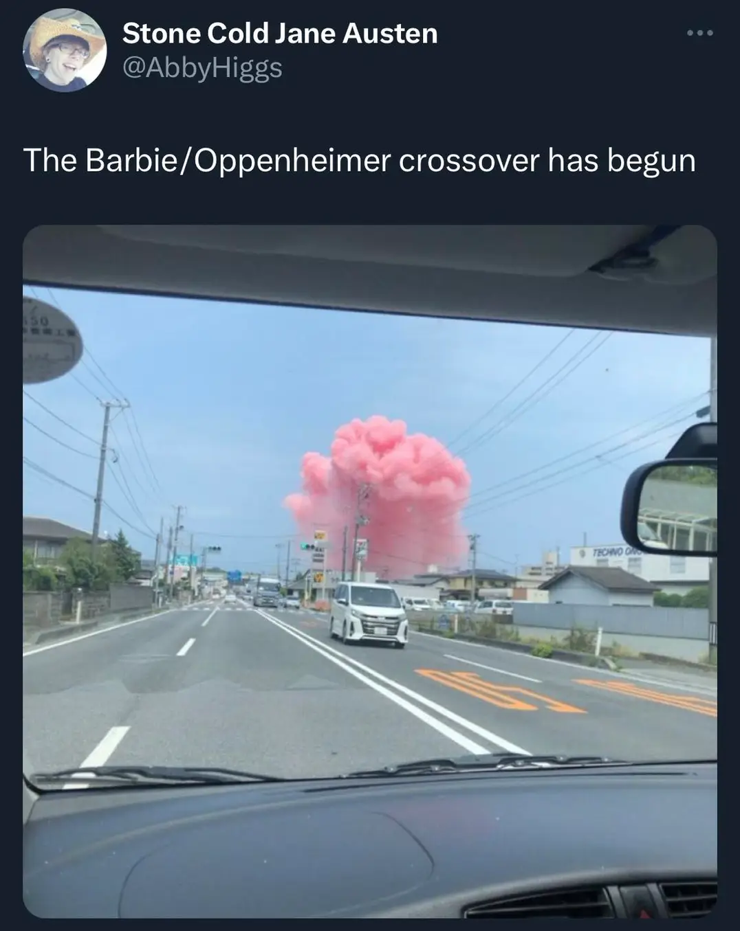 The meme is a humorous image of a massive explosion of pink cotton candy-like clouds in a suburban area. The image is captioned "The Barbie/Oppenheimer crossover has begun" in a tongue-in-cheek reference to the 2023 film Oppenheimer and the 2023 film Barbie, which are both set to be released around the same time. The joke implies that the two films' combined success is so explosive that it's creating a massive, pink, fluffy cloud.
