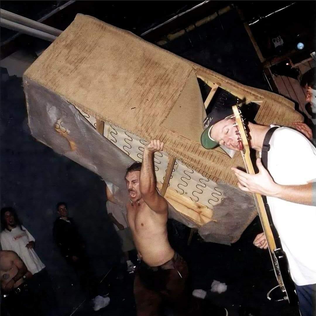 The meme is a photo of a person, likely a musician, being lifted onto a stage by a crowd of people. The image is captioned "when you're trying to get a good spot at a concert but the crowd is too excited". The person in the image appears to be struggling to maintain their balance as they are lifted higher and higher, with a look of panic on their face.