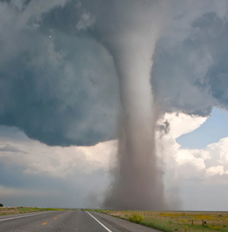 The meme is a photo of a massive tornado forming in the sky, with a funnel cloud descending from the clouds to the ground. The image is captioned "When you're trying to meet a deadline but the deadline is trying to meet you".