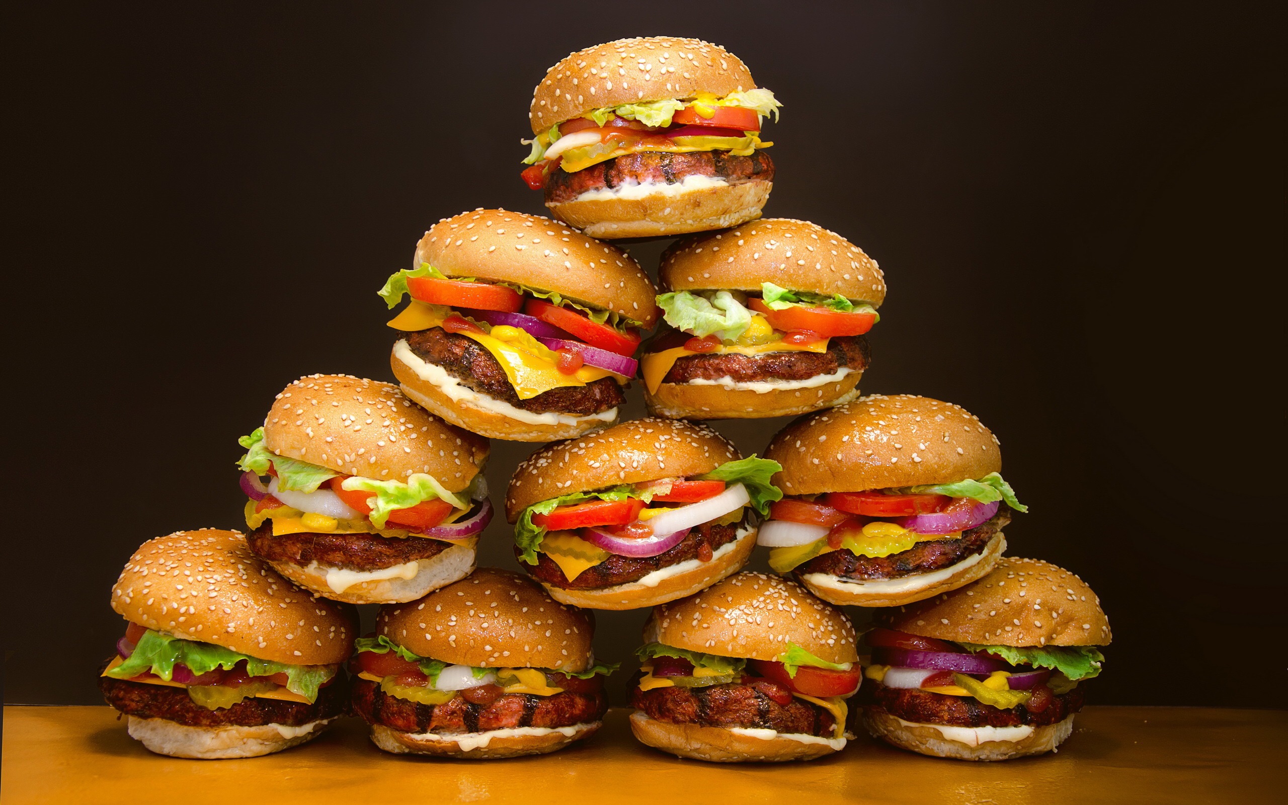 This meme is a picture of a pyramid of 10 stacked burgers, with each burger having multiple layers of ingredients. The image is captioned "10/10 would eat".