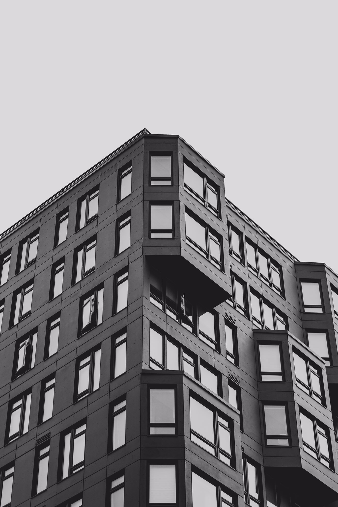 This meme is a humorous image of a large, empty apartment building with a sign on the door reading "No one lives here". The text is a play on the common phrase "no one lives here" and the absurdity of it being displayed on the door of a large, empty building.