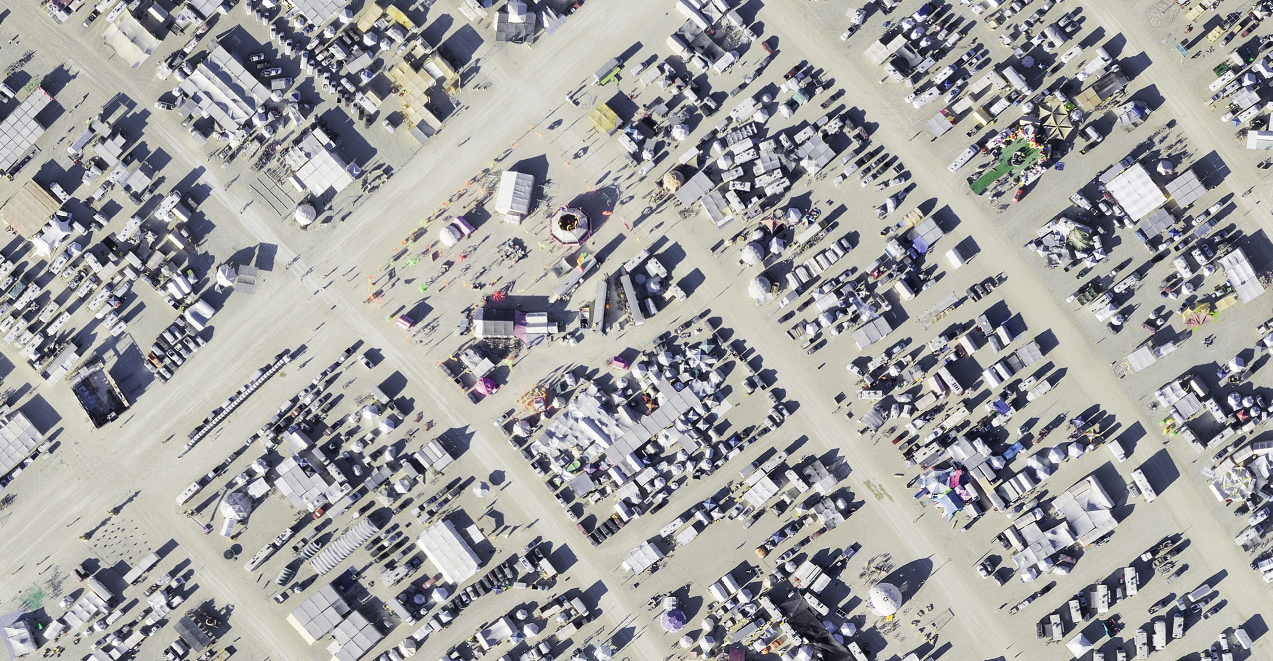 The meme is an image of a crowded and chaotic festival, likely a reference to Burning Man or another similar event. The image shows a sprawling landscape of tents, vehicles, and people, with a sense of overwhelming density and disorganization. The text "I'm not arguing, I'm just explaining why I'm right" appears in the image, likely in a humorous or ironic context.