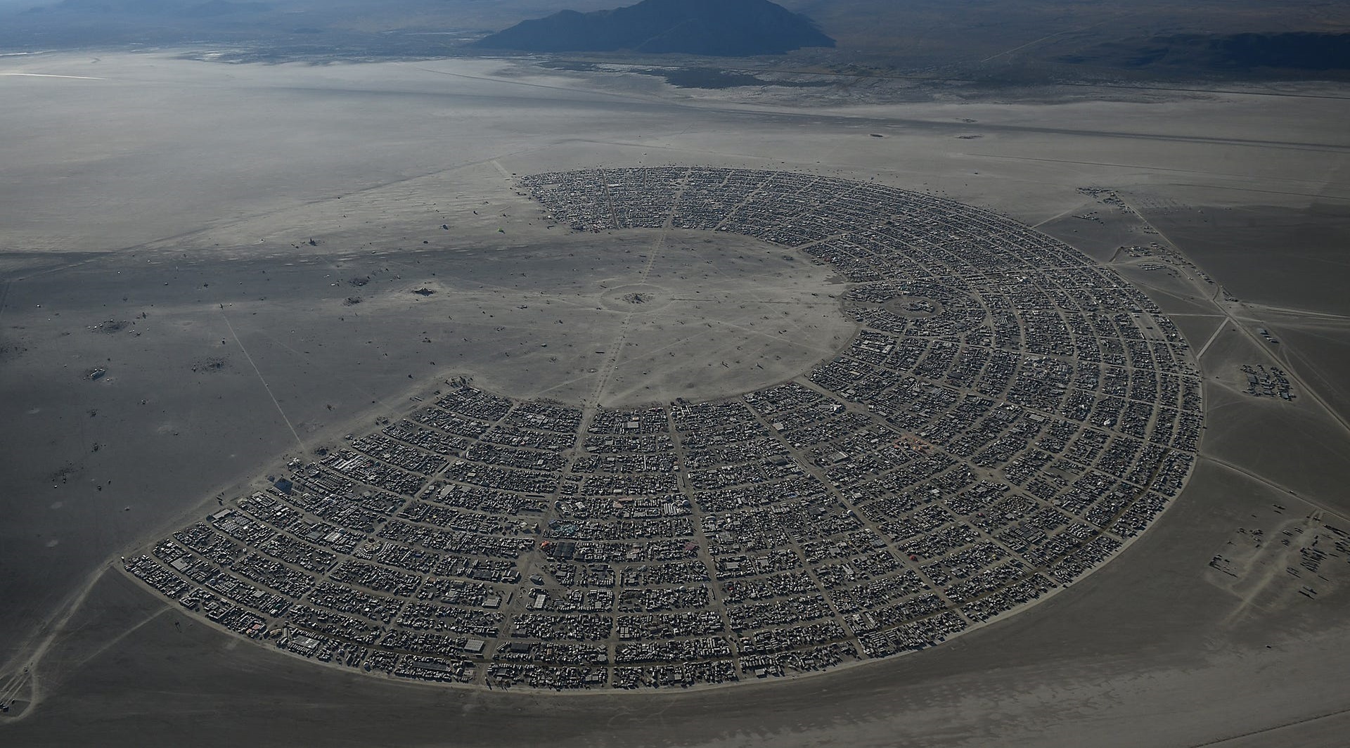 The meme is an image of a barren, dusty landscape with a single, tiny figure in the distance. The text "Burning Man 2023" is written in a small, awkward font at the top of the image, implying that the event has been moved to a much smaller location than its usual sprawling desert festival.