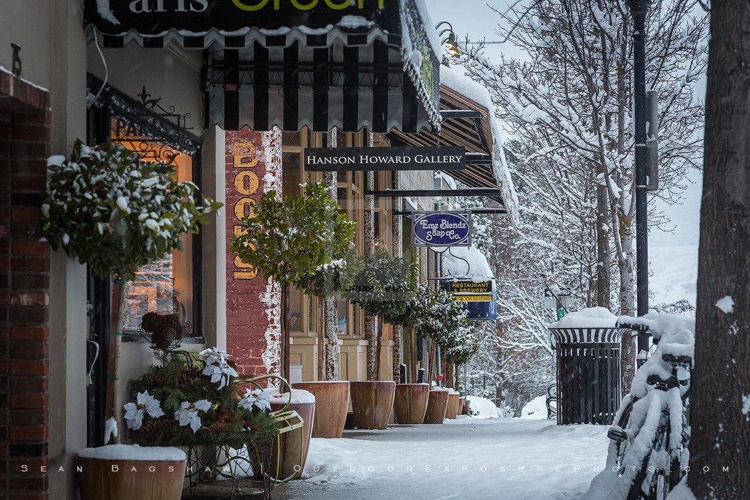 The meme is an image of a snow-covered street with a sign that reads "CLOSING" and another sign that says "WE'RE OPEN". The image is likely a humorous take on a common situation where a business would be expected to be closed due to the snow, but instead it's open and welcoming customers.