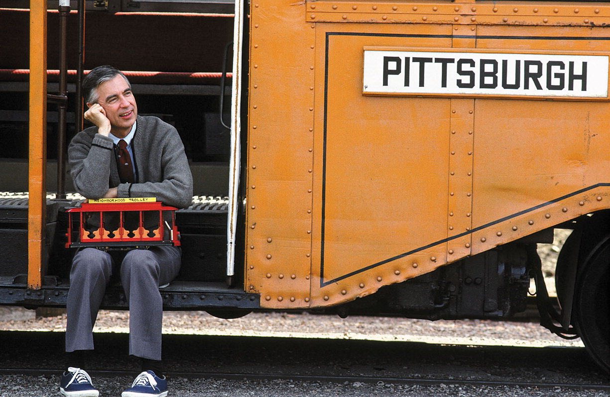 The meme is an image of Mister Rogers, a children's TV host, sitting in a trolley car. The text "I love you just the way you are" appears above the trolley car, referencing a phrase often said by Mister Rogers. The image is a humorous take on the classic Mister Rogers show, implying that even a beloved children's host could be a bit grumpy.